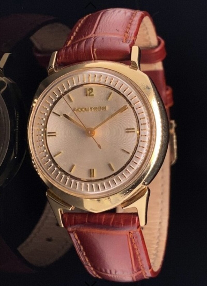 Front of watch showing 14K gold bezel, coined dial and no crown
