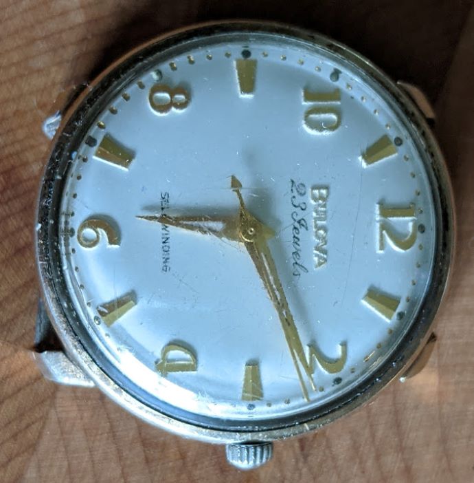 White dial with gold hands and minute markers (numbers)